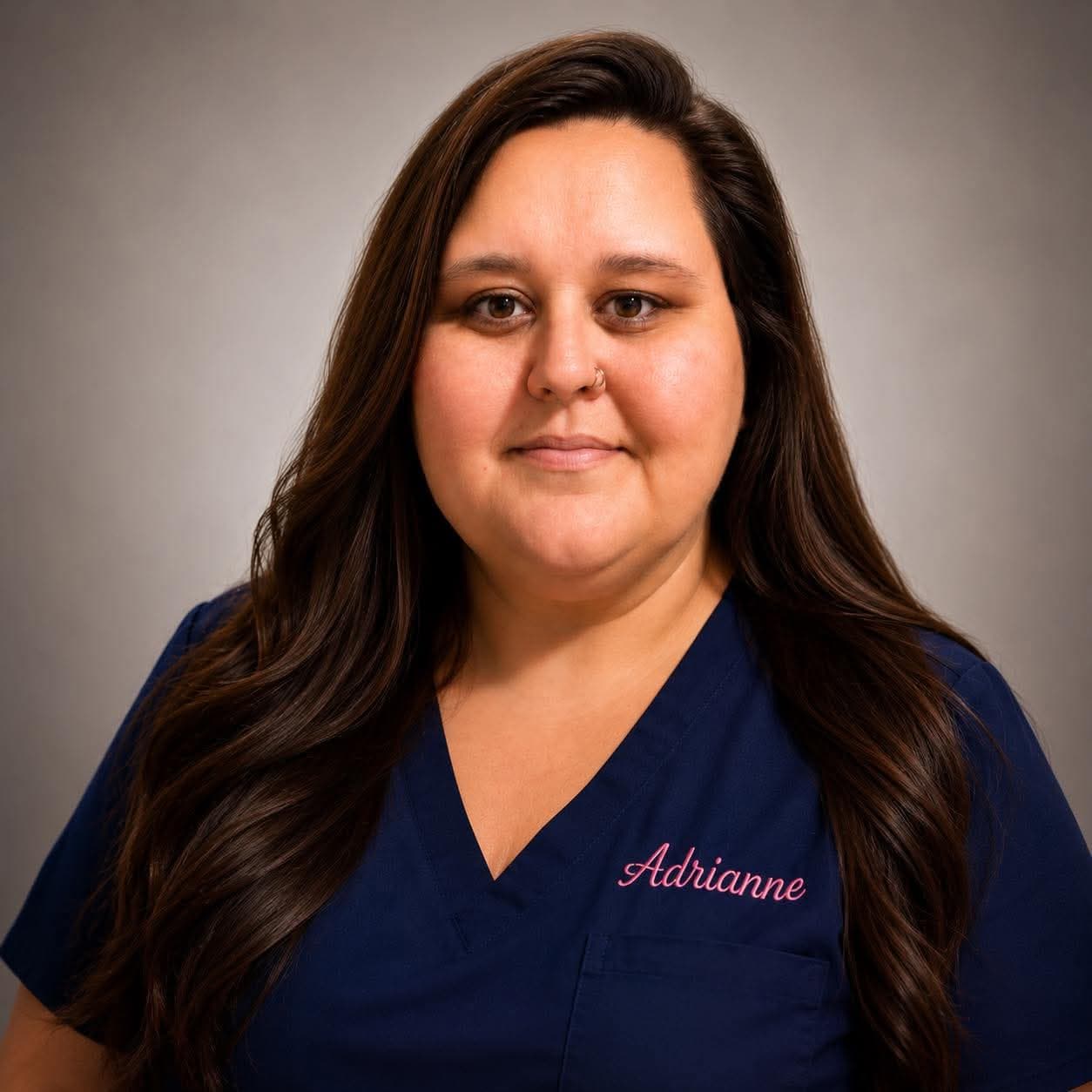 Adrianne Alverson in navy scrubs embroidered with her name.